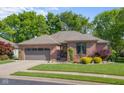Charming single-story brick home featuring a two-car garage and meticulously landscaped front yard at 3781 S Station Dr, Columbus, IN 47203