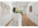 Bright hallway with hardwood floors leading to a living area with large windows and high ceilings at 3781 S Station Dr, Columbus, IN 47203