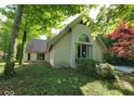Exterior of a light brick home with mature trees and an arched window detail at 3917 Knoll Wood Ln, Anderson, IN 46011