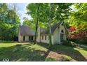 Exterior of a light brick home with mature trees and an arched window detail at 3917 Knoll Wood Ln, Anderson, IN 46011