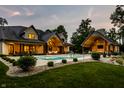 Beautiful backyard with a large in-ground pool, stone patio, and an outdoor fireplace at 4242 Watson Rd, Greenwood, IN 46143