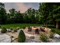 Custom fire pit surrounded by Adirondack chairs in a beautifully landscaped backyard at 4242 Watson Rd, Greenwood, IN 46143