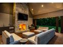 Outdoor living space with a stone fireplace, bar area, and comfortable seating at 4242 Watson Rd, Greenwood, IN 46143