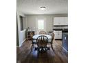 Cozy dining area with wood floors, a round table with chairs, and natural light from a nearby window at 450 Columbia Ct, Greenwood, IN 46142