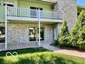 Inviting home showcasing a stone facade, second-story balcony, and lush landscaping at 5222 Nob Ln, Indianapolis, IN 46226