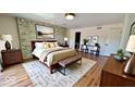 Relaxing main bedroom showcasing a stone accent wall, stylish furniture, and natural light at 5222 Nob Ln, Indianapolis, IN 46226