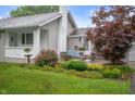 A cozy home featuring a well-maintained yard, complemented by a colorful garden and relaxing blue bench at 5330 W 56Th St, Indianapolis, IN 46254