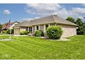 Brick home with a well-manicured lawn, attached garage, and mature trees, with an American flag at 551 Windward Ln, Plainfield, IN 46168