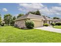 Brick home with a well-manicured lawn, attached garage, and mature trees at 551 Windward Ln, Plainfield, IN 46168