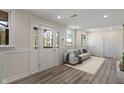 Bright entryway featuring modern wood flooring, a couch, a rug, and decorative glass door to the exterior at 6348 W 750 N, McCordsville, IN 46055