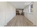 Bright hallway featuring modern wood flooring, white trim, and a decorative glass door to the exterior at 6348 W 750 N, McCordsville, IN 46055
