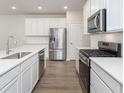 Modern kitchen featuring stainless steel appliances, white cabinets, quartz countertops, and a stylish backsplash at 7318 Shroyer Way, Noblesville, IN 46062