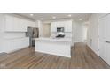 Contemporary kitchen boasts a large center island, stainless steel appliances, and ample white cabinetry at 7318 Shroyer Way, Noblesville, IN 46062