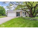 Charming ranch-style home with brick facade, attached garage, and mature landscaping at 7345 Monon Cir, Indianapolis, IN 46256