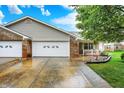Charming brick home with a two-car garage, freshly landscaped flowerbed, and bright white trim accents at 7840 Park Ward Pl, Indianapolis, IN 46259