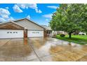A well-maintained brick-and-vinyl home featuring an attached two-car garage, a tidy lawn, and mature trees at 7840 Park Ward Pl, Indianapolis, IN 46259