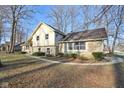 Angled view of exterior showing side yard, stone accents, walkway and mature trees at 7910 Teel Way, Indianapolis, IN 46256