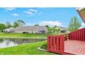 Relaxing backyard deck overlooking a serene pond with lush green lawn at 7937 Bentley Commons Dr, Indianapolis, IN 46259
