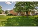 Spacious backyard featuring lush green grass and mature trees providing shade at 8133 Hazen Way, Indianapolis, IN 46216