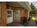 Inviting entryway with brick exterior and cozy seating area by the front door at 8133 Hazen Way, Indianapolis, IN 46216