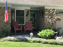 Inviting front porch with comfortable seating and blooming flowers at 9521 Gemini Dr, Indianapolis, IN 46229