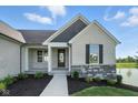 Elegant front porch showing the home's architectural details, landscaping and pond at 963 Apryl Dr, Greenwood, IN 46143