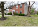 Two-story brick home showcasing the front yard with mature trees at 10764 Northhampton Dr, Fishers, IN 46038