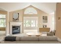 Inviting living room boasts a vaulted ceiling, fireplace, and an abundance of natural light at 11438 Winding Wood Dr, Indianapolis, IN 46235