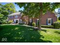 Charming brick two-story home with a well-manicured lawn and mature trees at 11536 Woods Bay Ln, Indianapolis, IN 46236