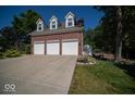 Three-car garage with white doors and brick facade at 11536 Woods Bay Ln, Indianapolis, IN 46236