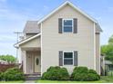 Charming two-story home with tan siding, dark shutters and a covered front porch at 1225 S Monroe St, Muncie, IN 47302