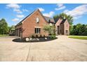 Spacious brick home with attached garage, complimented by lush greenery and landscaping at 12945 E 100 N, Columbus, IN 47203