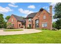 Elegant brick home showcasing a well-manicured lawn and spacious driveway at 12945 E 100 N, Columbus, IN 47203