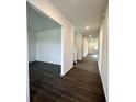 Inviting hallway with hardwood floors leads to a spacious open area, offering a seamless transition between rooms at 1534 Trichel Dr, Greenwood, IN 46143