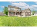 Inviting two-story home features a brick and siding facade, a manicured lawn, and a welcoming front porch at 1603 Quinn Creek Dr, Brownsburg, IN 46112
