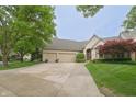 Charming two-story home with a three-car garage, landscaped yard, and a welcoming brick facade at 1614 Rosebud Ln # 83, Greenwood, IN 46143