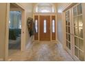 Elegant foyer features tile flooring, and a beautiful wooden door with transom window at 1614 Rosebud Ln # 83, Greenwood, IN 46143