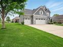 Well-maintained two-story home featuring a three-car garage, stone accents, and lush green lawn at 165 N Bend Dr, Greenwood, IN 46142
