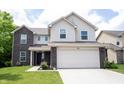 Charming two-story home with a two-car garage, landscaped yard, and a combination of brick and siding at 17696 Arryne E Dr, Noblesville, IN 46062
