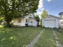 View of a house and detached garage from the backyard, showing a spacious grassy area at 1830 Jefferson St, Anderson, IN 46016