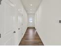 Clean, bright hallway with hardwood flooring leading to a front door with glass window at 19762 Highclere Lane, Sheridan, IN 46069