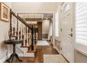 Elegant foyer featuring hardwood floors, a staircase with a black railing, and ample natural light at 2055 Mulsanne Dr, Zionsville, IN 46077