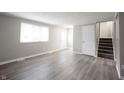 Bright living room featuring wood-look flooring, neutral paint, and staircase access at 2740 Pawnee Dr, Indianapolis, IN 46229
