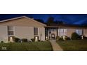 Inviting single-story home with a well-lit exterior and cozy front porch at night at 310 Styleline Dr, Mooresville, IN 46158