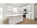 Modern kitchen featuring a central island, stainless steel appliances, and ample cabinet space at 3226 Promenade Way, Brownsburg, IN 46112