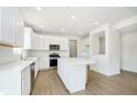 Bright kitchen featuring white cabinetry, stainless steel appliances, subway tile backsplash, and an island at 3226 Promenade Way, Brownsburg, IN 46112