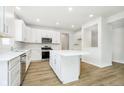 Bright, white kitchen with stainless steel appliances and a center island at 3226 Promenade Way, Brownsburg, IN 46112