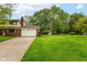 Spacious backyard with lush green grass, mature trees, and a view of the surrounding neighborhood at 3325 Broadview Ct, Indianapolis, IN 46227