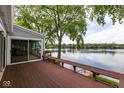 Back deck with bench overlooking a lake with mature trees, and sliding glass doors to home at 3430 Bay Road South Dr, Indianapolis, IN 46240