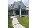 Two-story home boasting a covered front porch, green lawn, and a concrete walkway leading to the entrance at 3614 Guilford Ave, Indianapolis, IN 46205